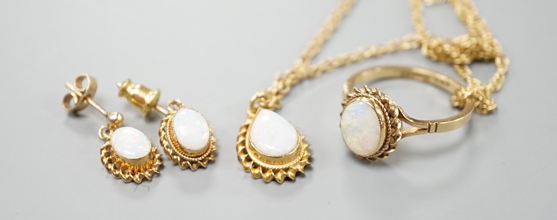 A modern suite of 9ct gold and white opal jewellery, comprising a ring, pendant on chain and pair of earrings, gross weight 9.1 grams.
